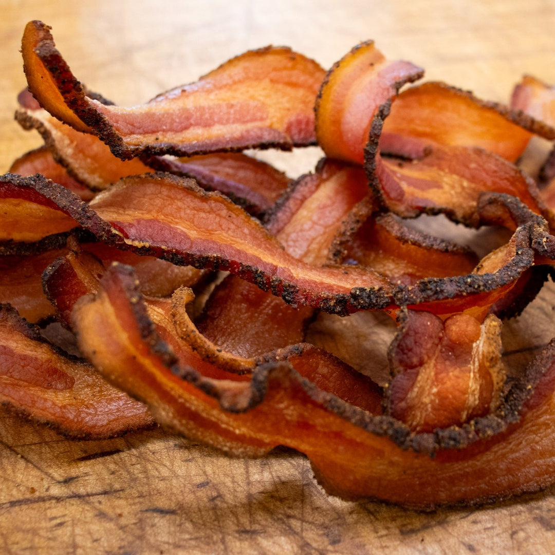 Thick-cut Bourgeois Cajun Smoked Bacon, perfectly seasoned with bold Cajun spices and slow-smoked over natural hardwoods for a rich, smoky flavor. A Southern favorite for breakfast, sandwiches, or cooking