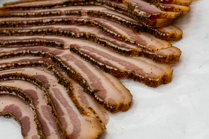 Thick-cut Bourgeois Cajun Smoked Bacon, perfectly seasoned with bold Cajun spices and slow-smoked over natural hardwoods for a rich, smoky flavor. A Southern favorite for breakfast, sandwiches, or cooking